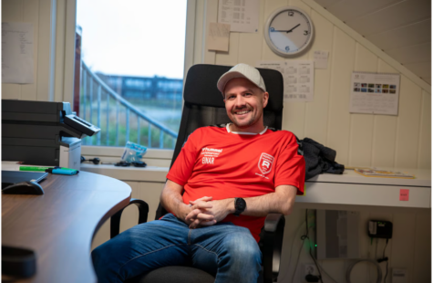 RIL barnehage vil bli Norges beste i lek En mann med skyggelue sitter i en kontorstol på et kontor.