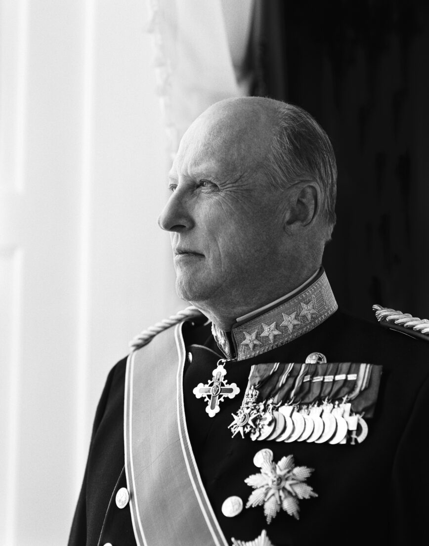 Nøye profilbilde av en eldre person i elegant militæruniform med medaljer og stjerner, ser ut mot venstre mot en lys bakgrunn.