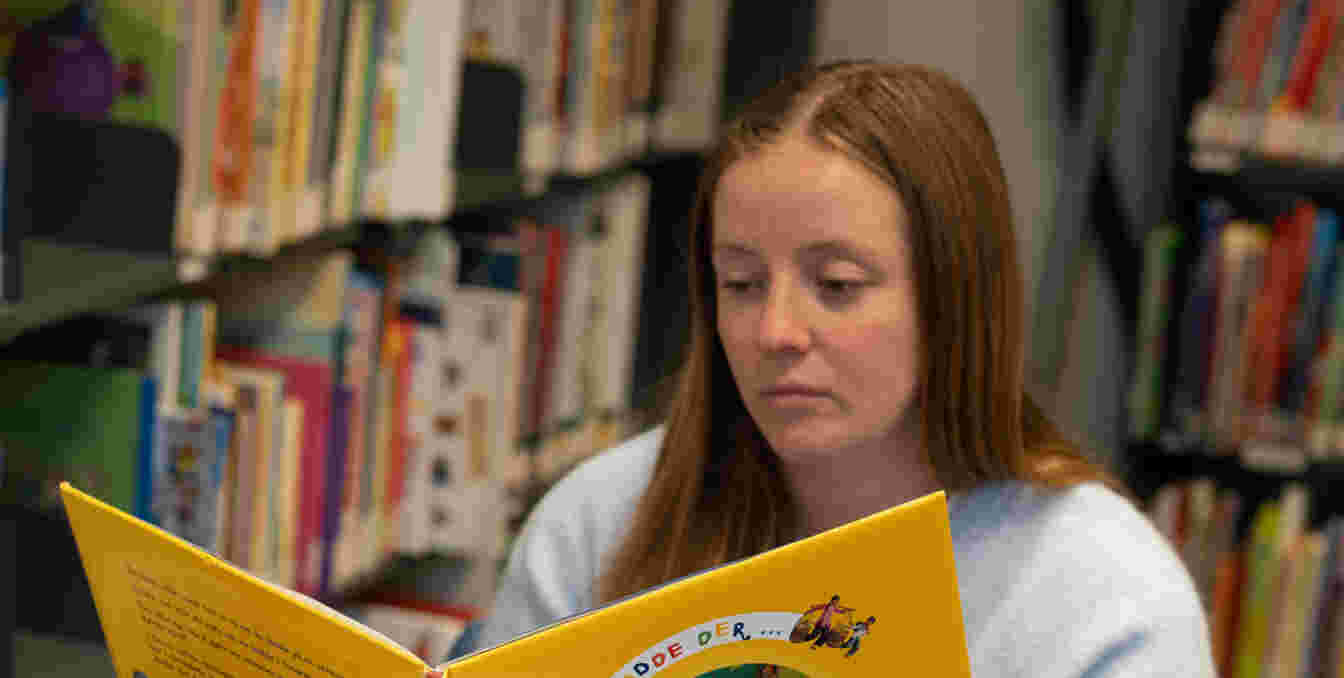 Ung kvinne som leser i en barnebok