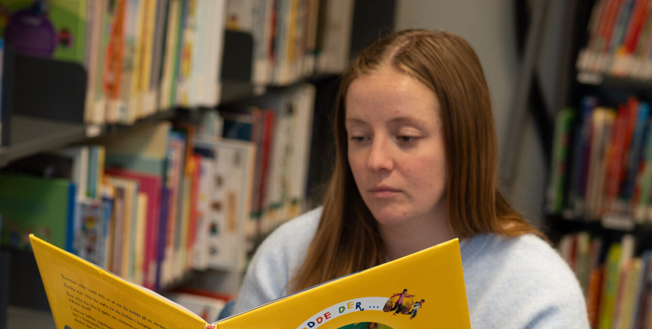 Ung kvinne som leser i en barnebok