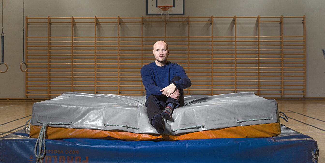 En av lærerne ved DMMH sittende på en sakkosekk i gymsalen