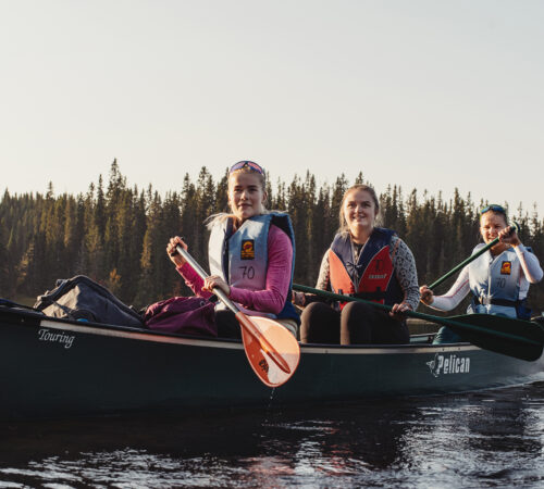 Tre kvinnelige studenter ute i en kano
