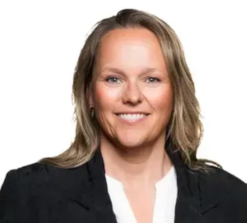 Profesjonell gruppeportrett av en person i svart blazer og hvit blouse, smilende, nøytral hvit bakgrunn, bokstavelig og formell for forretningsbruk.