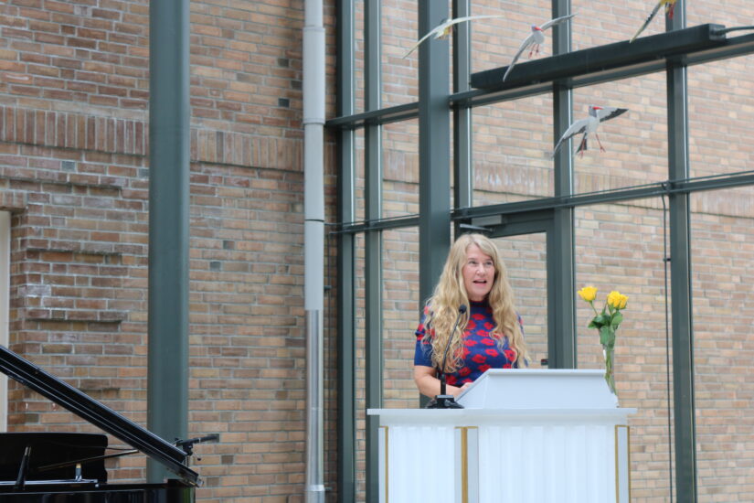 En kvinne står ved en talerstol.