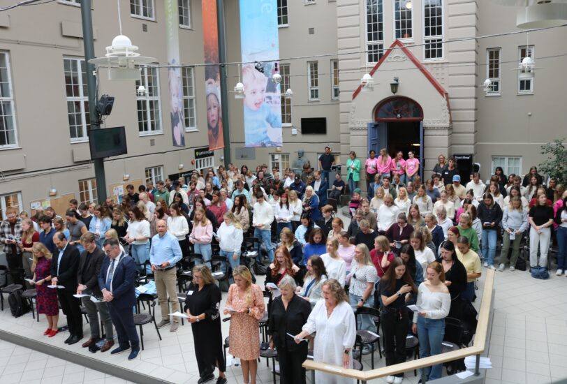 Et bilde tatt ovenfra av en sal der alle synger.