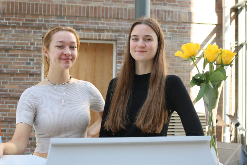 To unge kvinner står ved en talerstol.