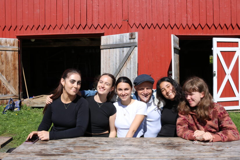 5 unge kvinner og en mann sitter på en benk.